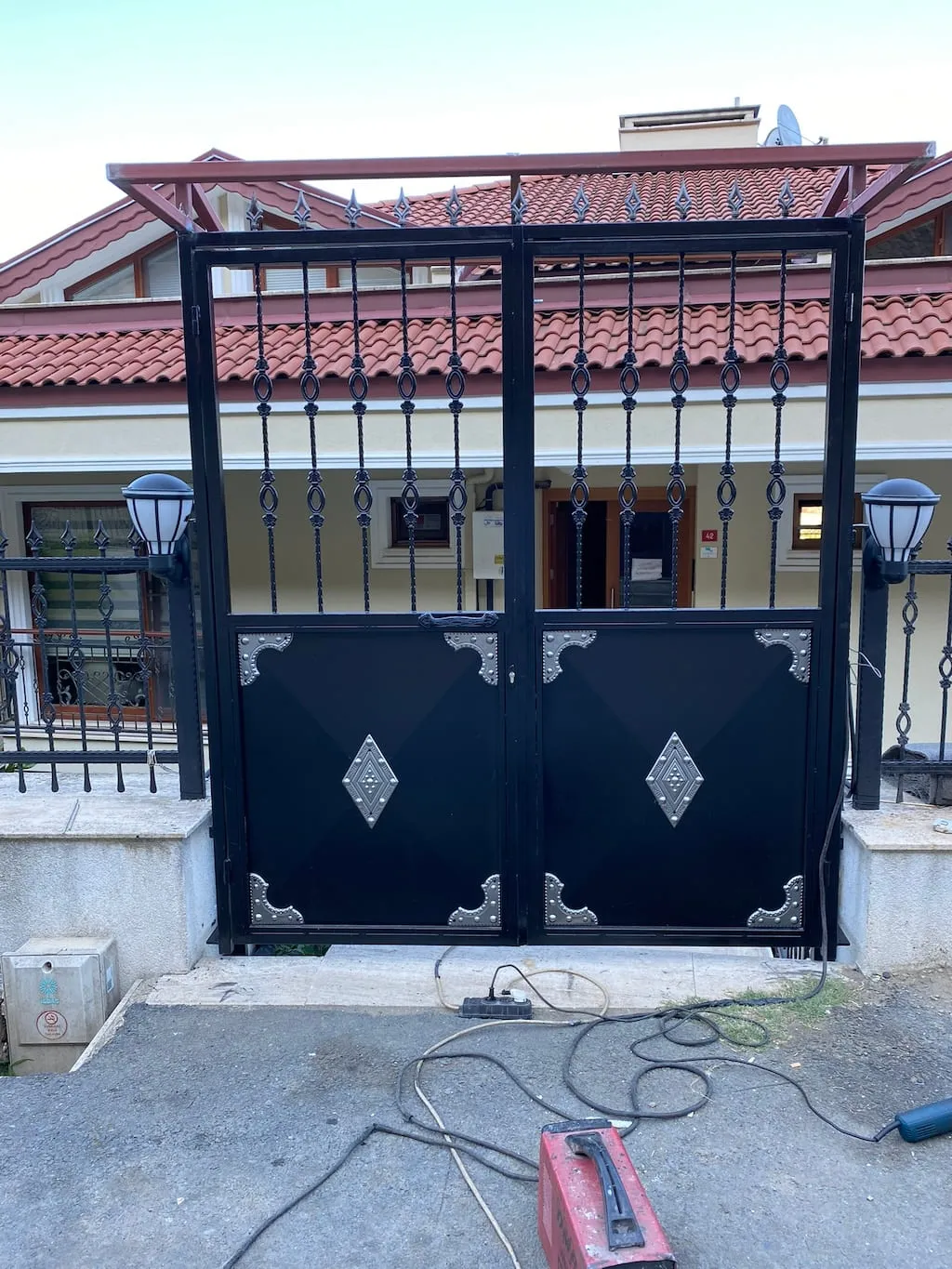 Villa girişine monte edilen ferforje süslemeli çift kanatlı demir bahçe kapısı