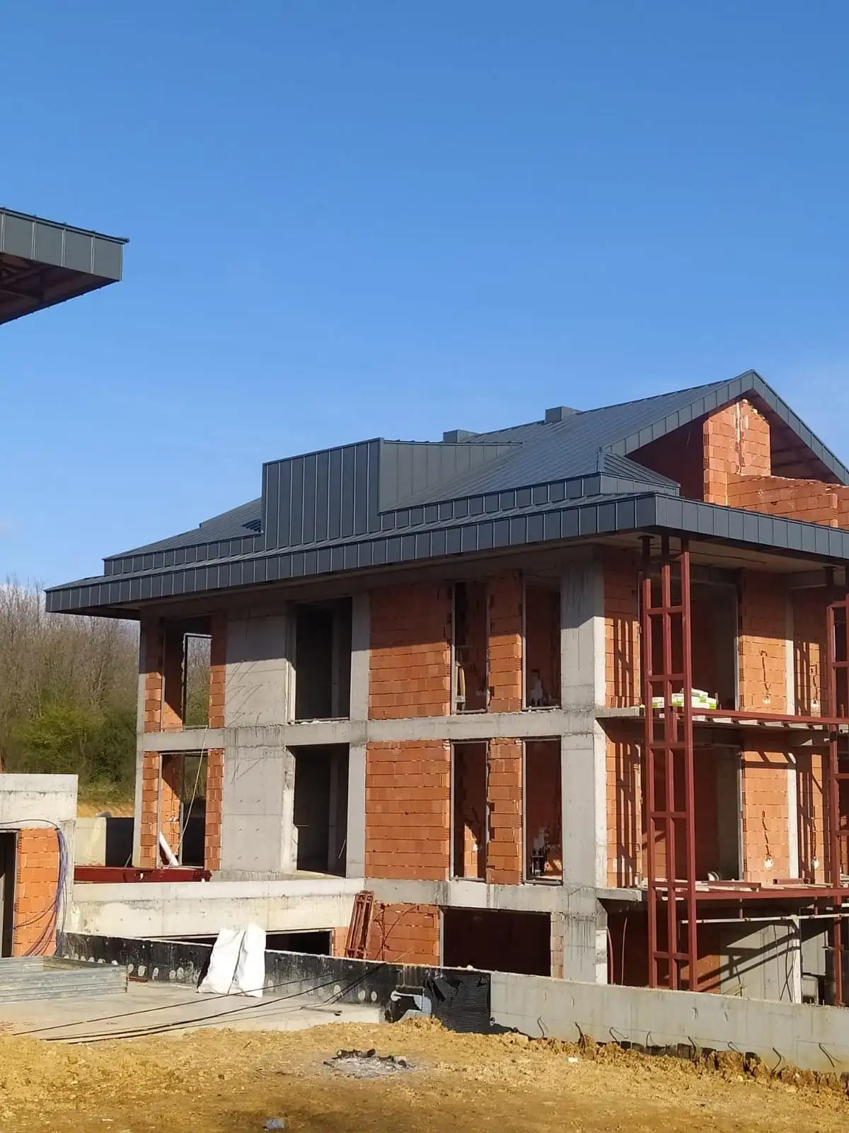 Müstakil evde tamamlanmış antrasit kenetli metal çatı, geniş saçak dönüşü ve çatı çıkıntısı